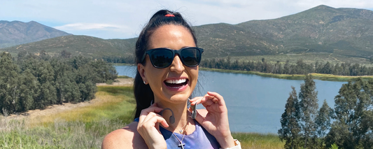 Image of running coach Kim Clark outside wearing Shokz OpenRun wireless headphones